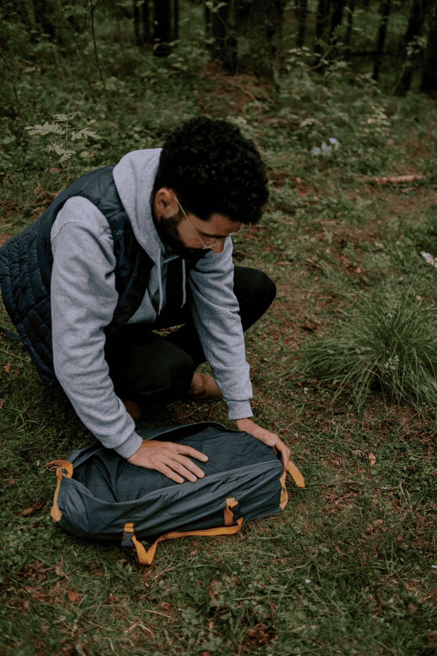 Survival card suppliers: man in gray hoodie holding a bag