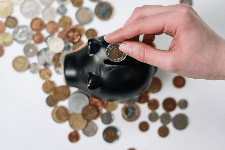 Survival card manufacturing: woman putting coin into piggy bank