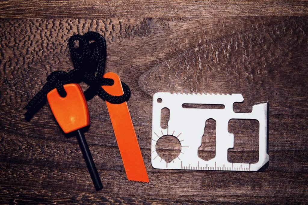 Survival card manufacturing: ferro rod with striker and survival card on a wooden surface.