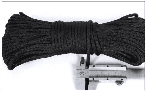 Paracord manufacturing: caliper measuring the diameter of a black paracord.