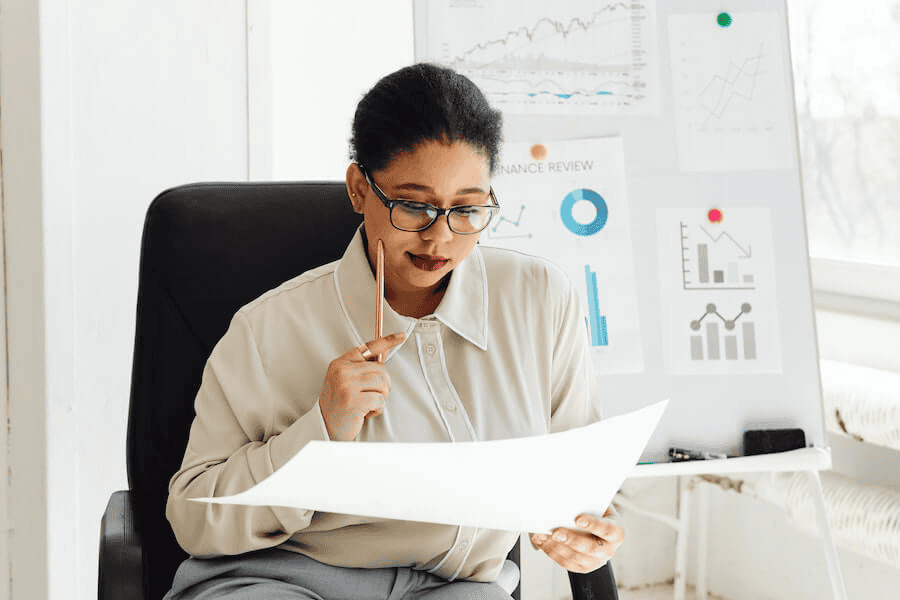 Paracord manufacturer: woman sitting on office chair and holding a white paper.