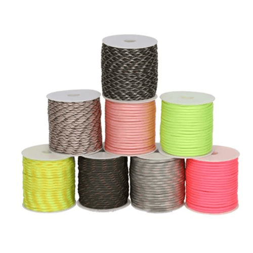 Paracord factory: a stack of paracord in spool on a white surface.