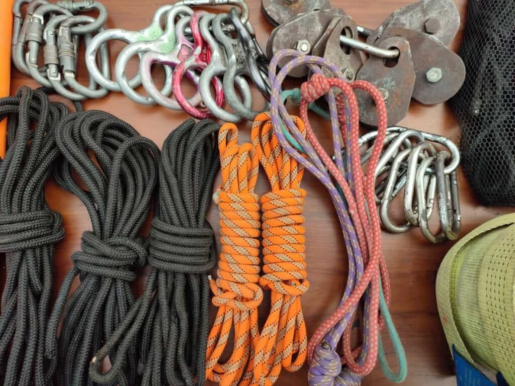 Paracord wholesale: emergency ropes and equipment on a wooden table.