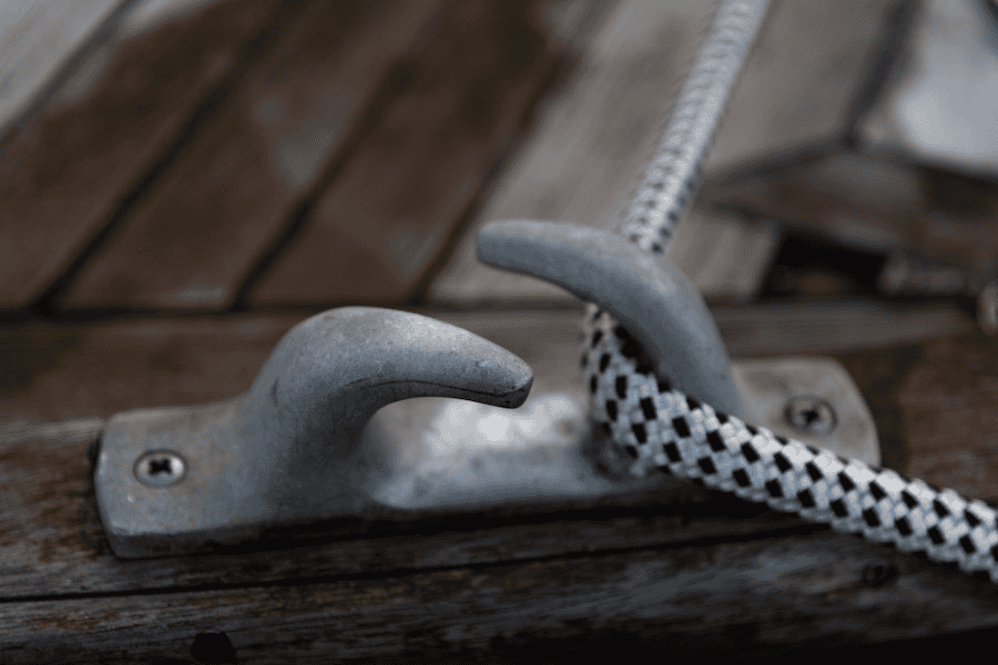 Paracord wholesale: Strong mooring rope on metal hook on shop deck.