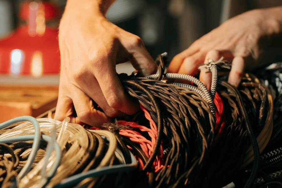 Paracord factory: person holding different colors of ropes.