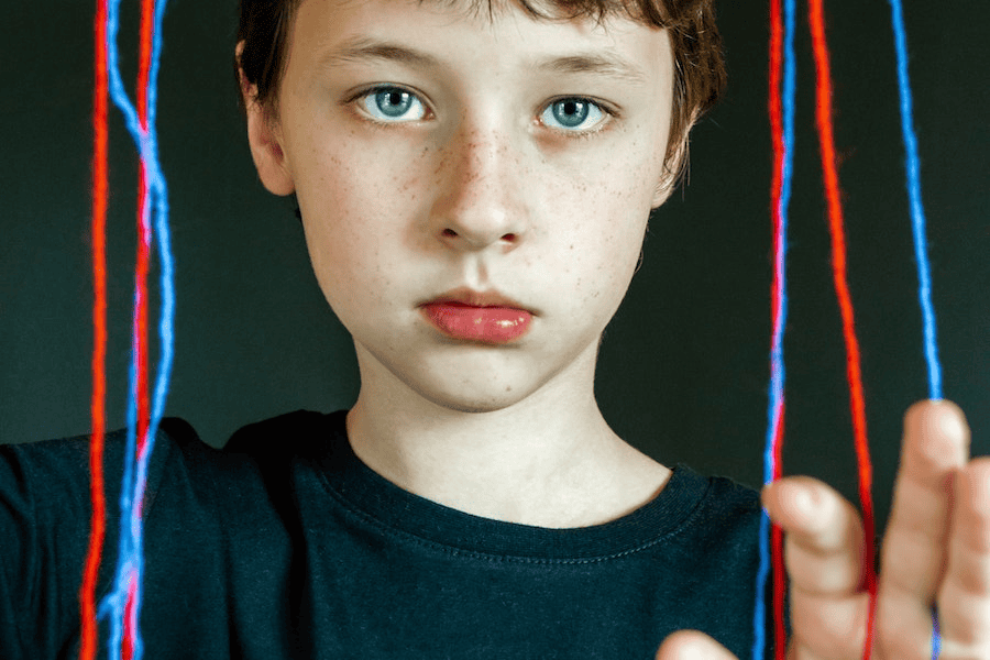Paracord manufacturer: Boy in black crew neck t-shirt in front of colorful yarns.