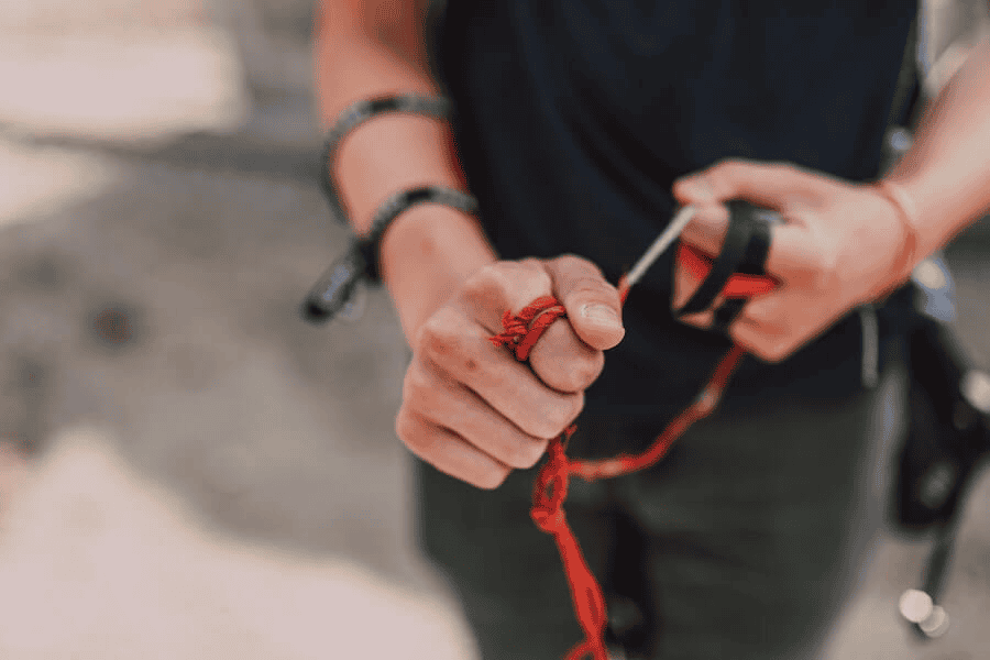 Paracord manufacturer: Woman's hands pulling an orange paracord.