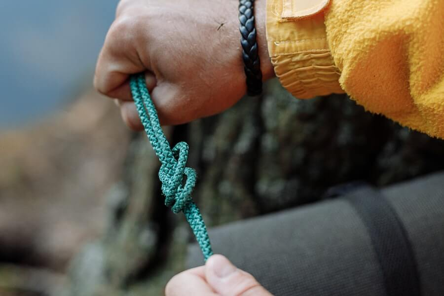 Paracord manufacturer: A man tugging a green rope.